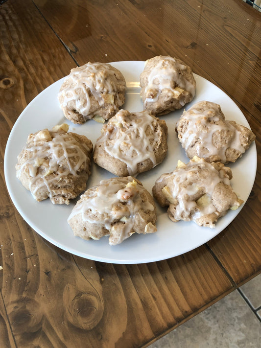 Baked apple fritters with vanilla glaze on a table