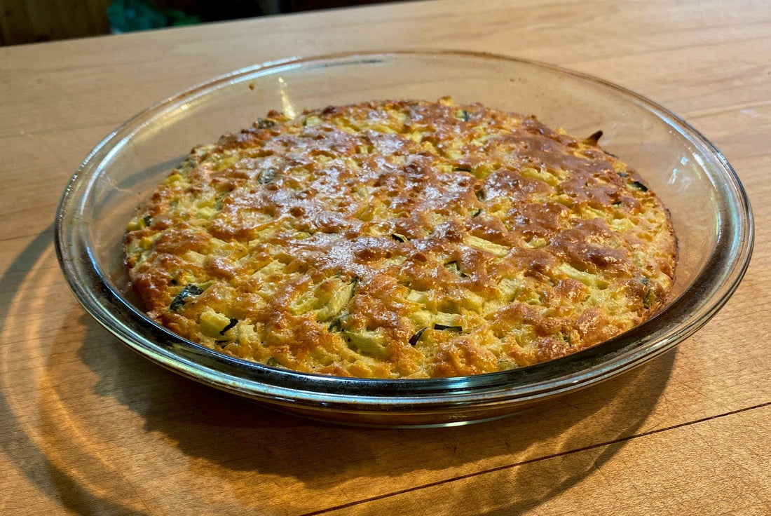 Zucchini Quiche in a glas backing pan on a wooden cutting board