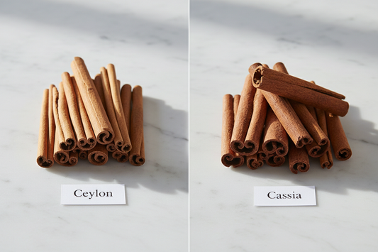 Ceylon and Cassia cinnamon sticks side by side on marble — Ceylon on the left is thin, pale, and tightly rolled; Cassia on the right is thick, hard, and dark reddish-brown. The visual difference is as significant as the nutritional one.
