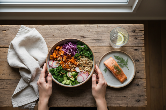 Overhead view of a mindful eating practice with hands near a healthy meal on a wooden table